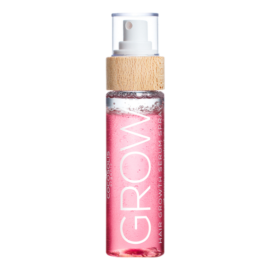 A bottle of the COCOSOLIS Grow Serum in a clear bottle showing the pink liquid with a bamboo top