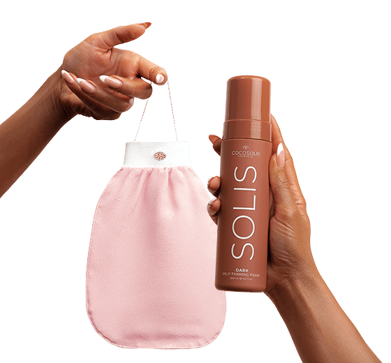 A woman holding the COCOSOLIS Exfoliating Mitt and the DARK Solis Self-Tanner